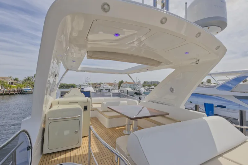 Slide: The Image of 2015 Azimut 64 Flybridge yacht with spacious outdoor seating and dining area. - 14