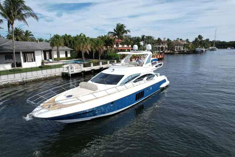 Slide: The Image of 2015 Azimut 64 Flybridge yacht cruising on a scenic waterway. - 3