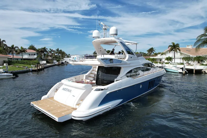 Slide: The Image of 2015 Azimut 64 Flybridge yacht cruising in a scenic waterfront neighborhood. - 5