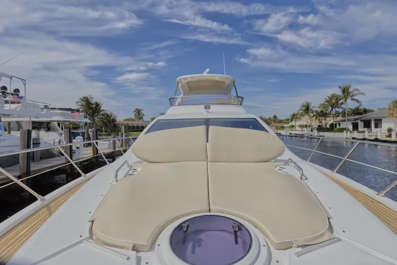 Slide: The Image of 2015 Azimut 64 Flybridge yacht with sunbathing area, docked in a marina. - 8