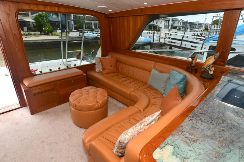 Slide: The Image of Luxurious interior of a 1988 Bertram 54 Convertible yacht with leather seating and marina view. - 25