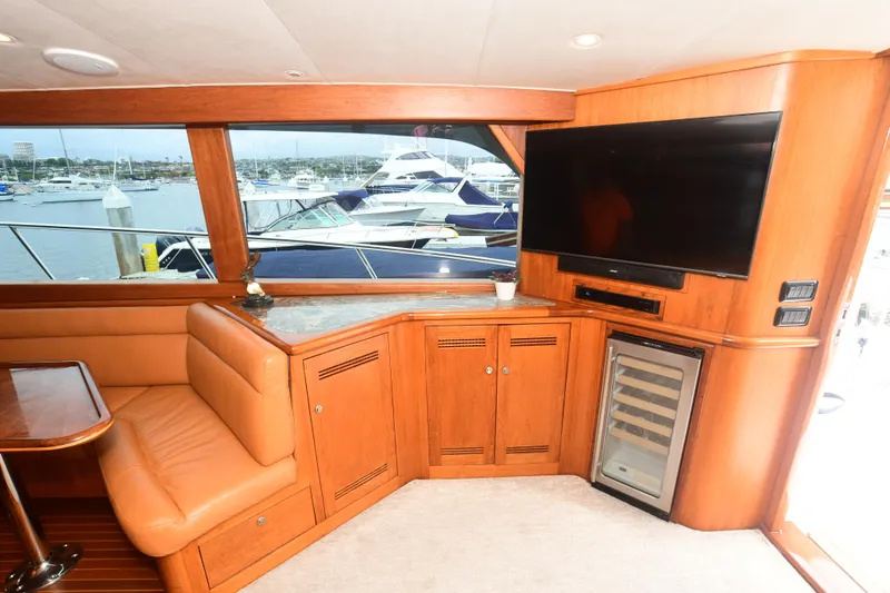 Slide: The Image of Interior of 1988 Bertram 54 Convertible yacht with seating, TV, and marina view. - 32