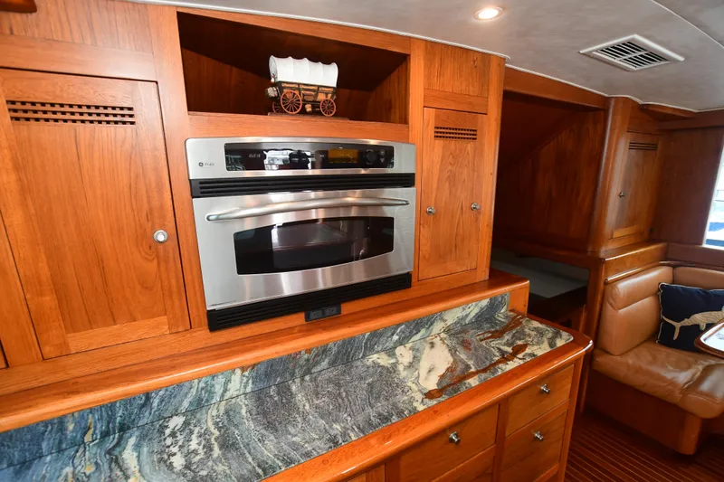 Slide: The Image of 1988 Bertram 54 Convertible yacht kitchen with wood cabinets and marble countertop. - 34
