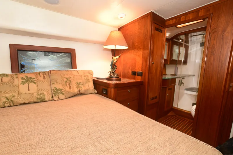 Slide: The Image of Luxurious bedroom interior of a 1988 Bertram 54 Convertible yacht with wooden furnishings. - 43