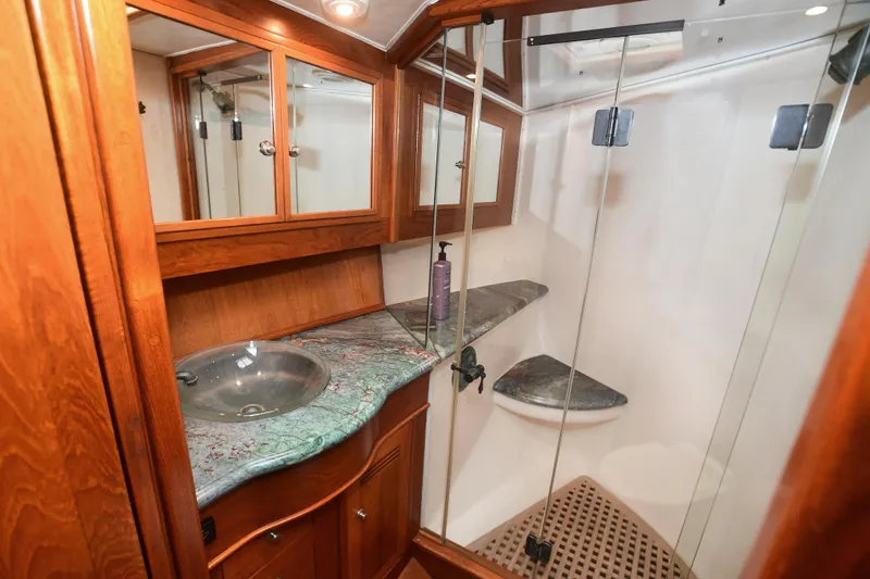 Slide: The Image of 1988 Bertram 54 Convertible yacht bathroom with glass shower and wooden cabinetry. - 44
