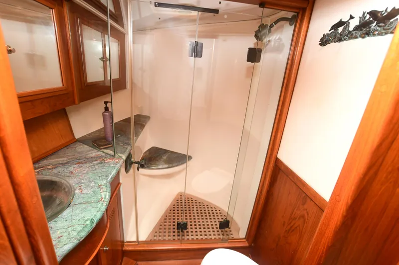 Slide: The Image of 1988 Bertram 54 Convertible yacht bathroom with glass shower and wooden cabinetry. - 46