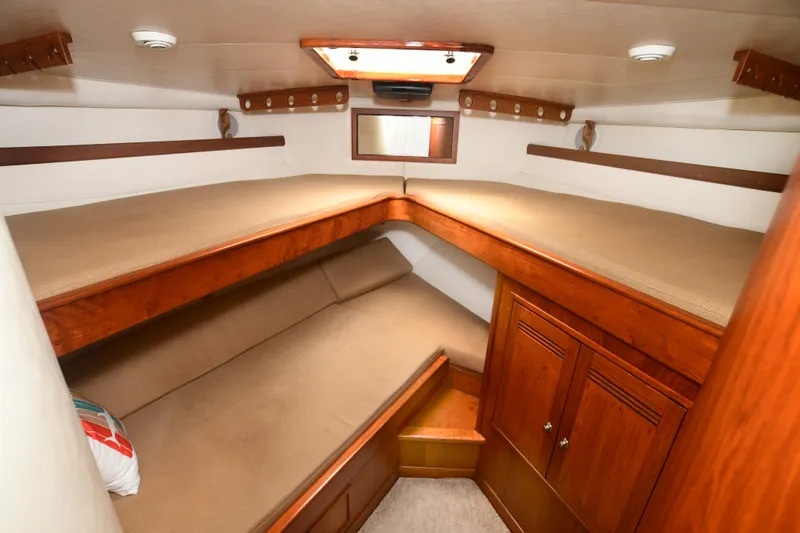 Slide: The Image of 1988 Bertram 54 Convertible cabin with wooden furnishings and twin beds. - 47