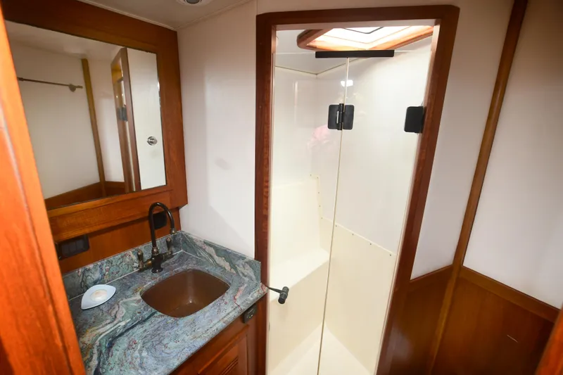 Slide: The Image of 1988 Bertram 54 Convertible bathroom with sink, mirror, and shower. - 48
