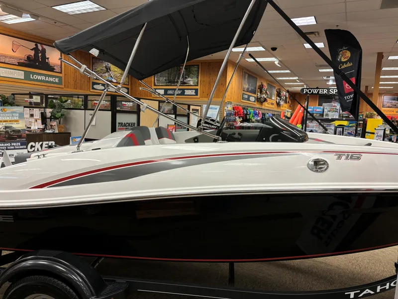 Slide: The Image of 2023 Tahoe T16 boat on display in a showroom with accessories. - 1
