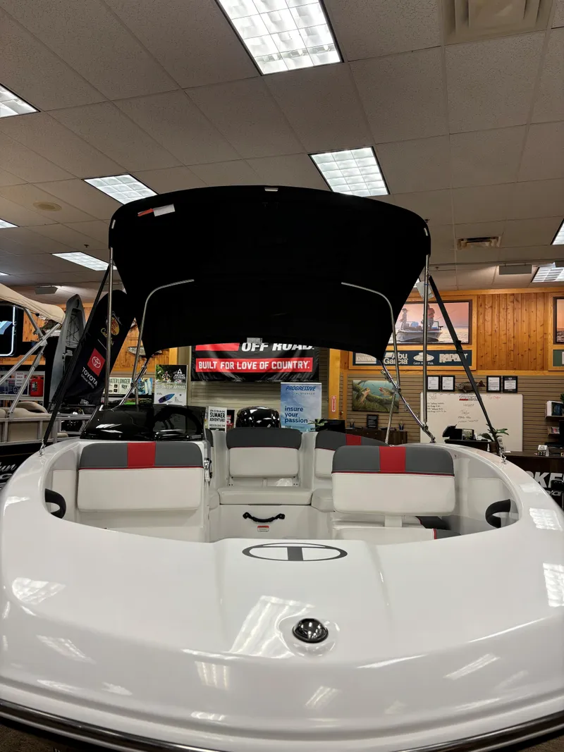 Slide: The Image of 2023 Tahoe T16 boat on display in showroom with canopy and seating. - 2