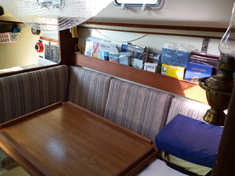 Slide: The Image of Cozy interior of 1983 Watkins 32 sailboat with books and striped seating. - 15