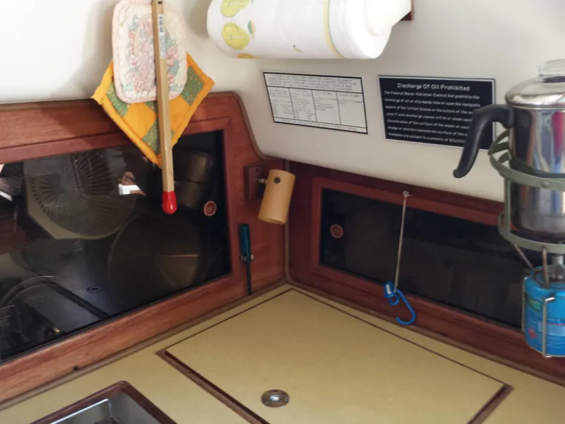Slide: The Image of Interior of a 1983 Watkins 32 sailboat galley with wooden accents and kitchen essentials. - 18