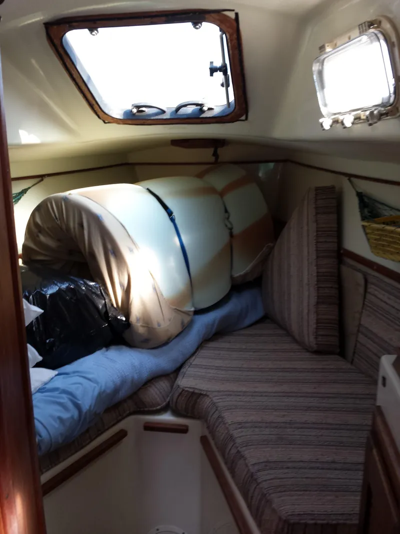 Slide: The Image of 1983 Watkins 32 sailboat interior with striped cushions and a rolled-up sail. - 24