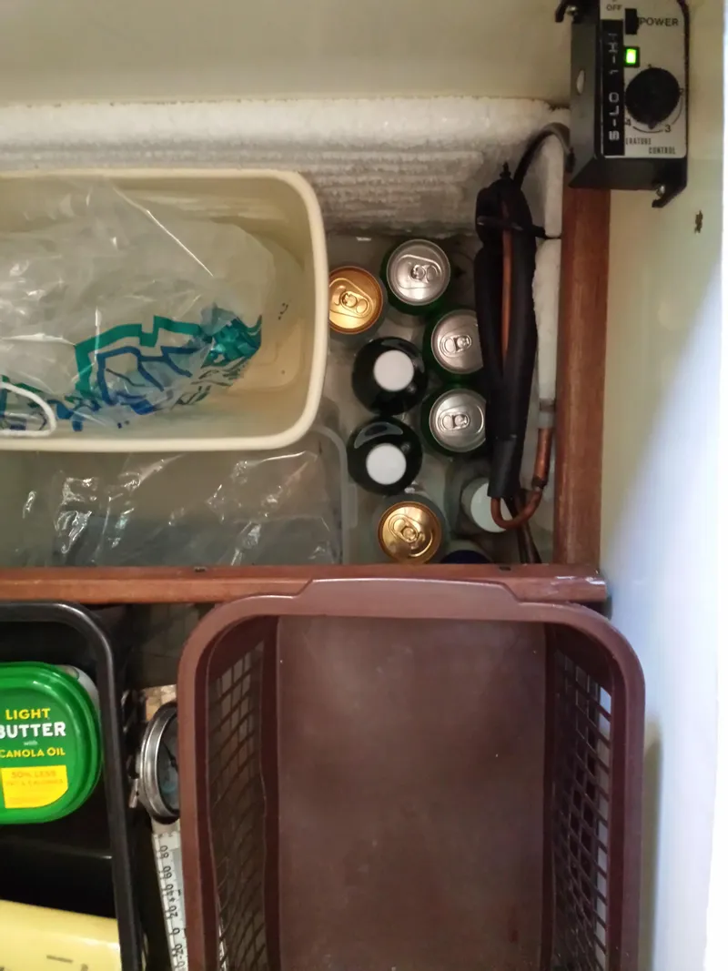 Slide: The Image of Refrigerator interior with drinks, butter, and storage basket in a 1983 Watkins 32 model. - 28