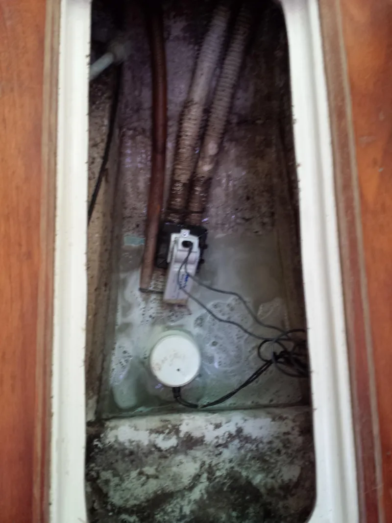 Slide: The Image of Bilge compartment of 1983 Watkins 32 sailboat with wiring and hoses visible. - 33