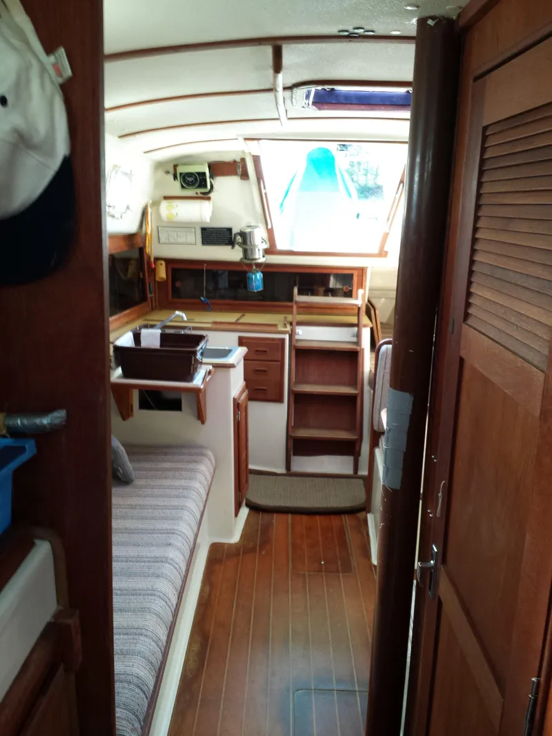 Slide: The Image of Interior of a 1983 Watkins 32 sailboat with wood finishes and cozy seating. - 36