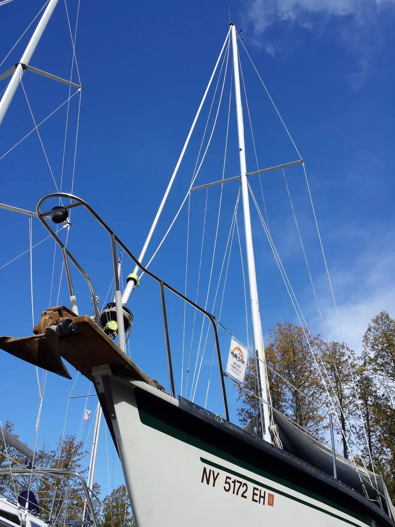Slide: The Image of 1983 Watkins 32 sailboat with tall mast against blue sky, NY registration visible. - 38