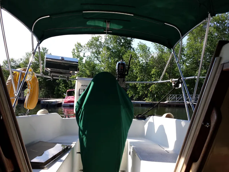Slide: The Image of Cockpit view of a 1983 Watkins 32 sailboat docked, with green canopy and covered equipment. - 4