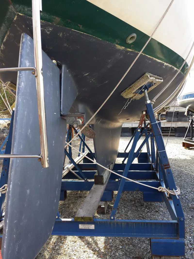 Slide: The Image of 1983 Watkins 32 sailboat on a blue stand, showing keel and rudder details. - 43