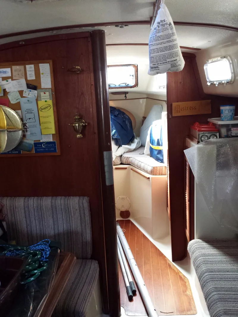 Slide: The Image of Interior of a 1983 Watkins 32 sailboat with cozy seating and wooden accents. - 49