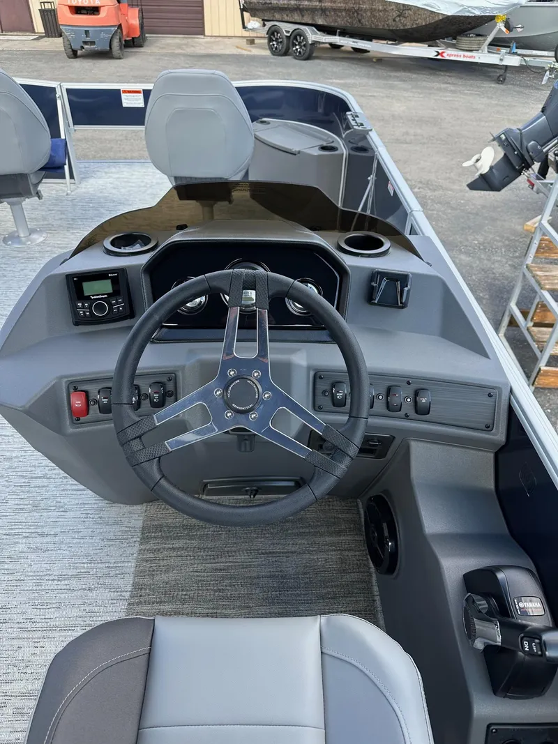 Slide: The Image of 2025 Bennington 22 SF Pontoon boat dashboard with steering wheel and controls. - 16