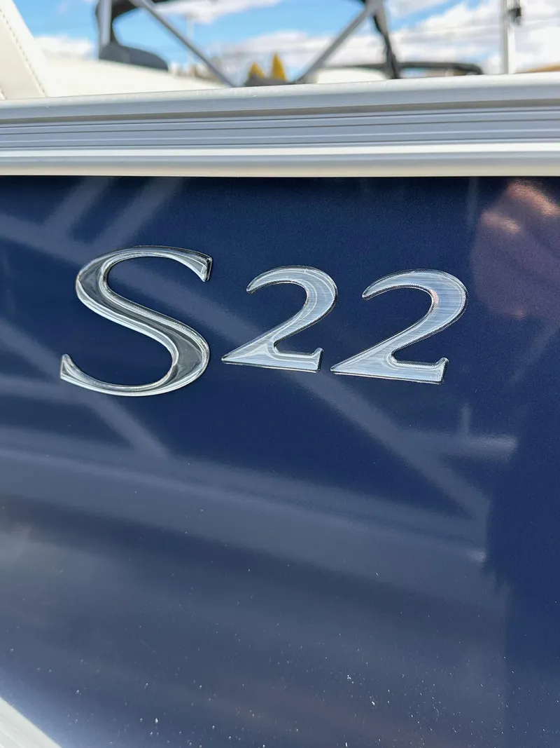 Slide: The Image of 2025 Bennington 22 SF Pontoon, close-up of "S22" emblem on blue surface. - 29