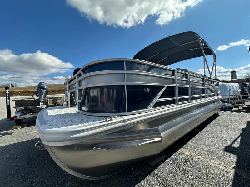 Slide: The Image of 2025 Bennington 22 SF Family Pontoon with four fishing seats, parked under a clear blue sky. - 30