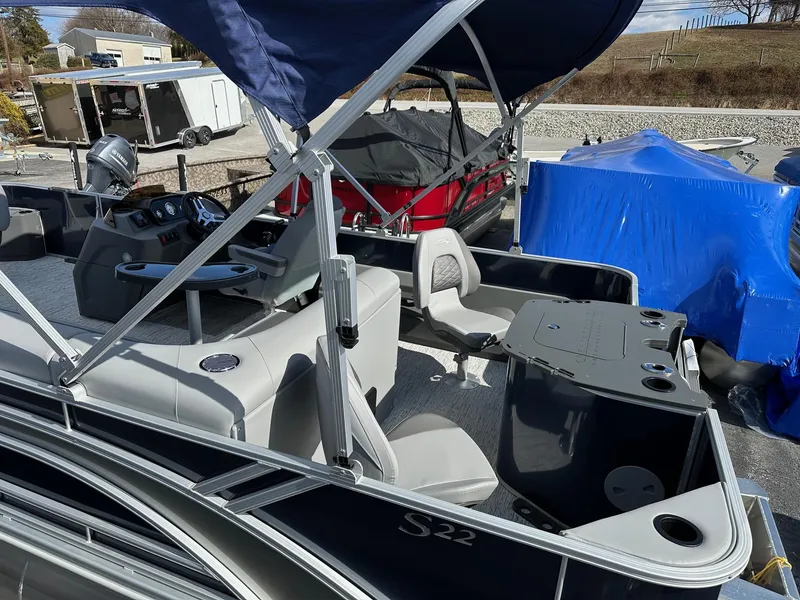 Slide: The Image of 2025 Bennington 22 SF pontoon boat with fishing seats and canopy, parked outdoors. - 33