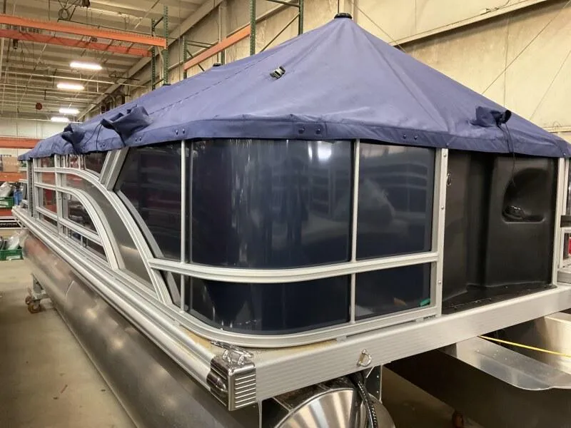 Slide: The Image of 2025 Bennington 22 SF pontoon boat with blue cover in warehouse setting. - 5