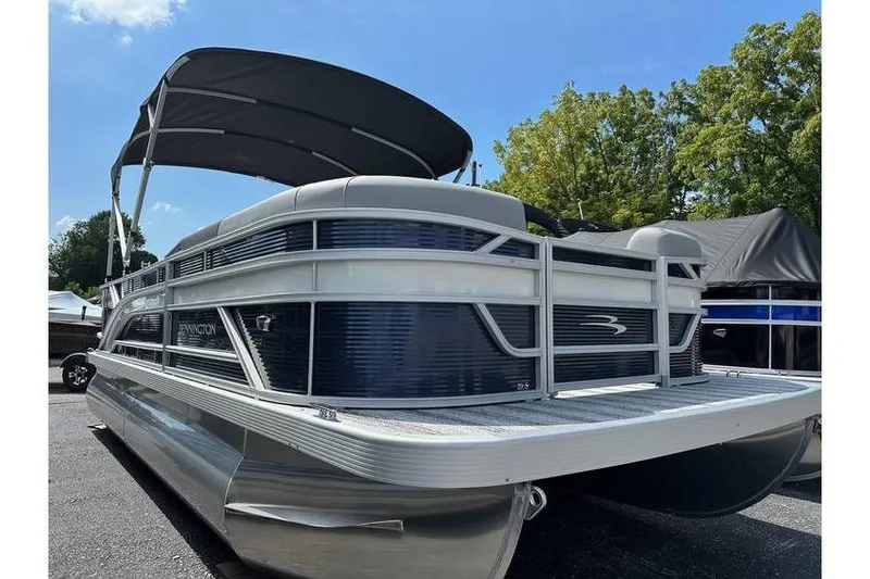 The Image of 2026 Bennington 20 SS pontoon boat with canopy, parked outdoors under blue sky. - 4