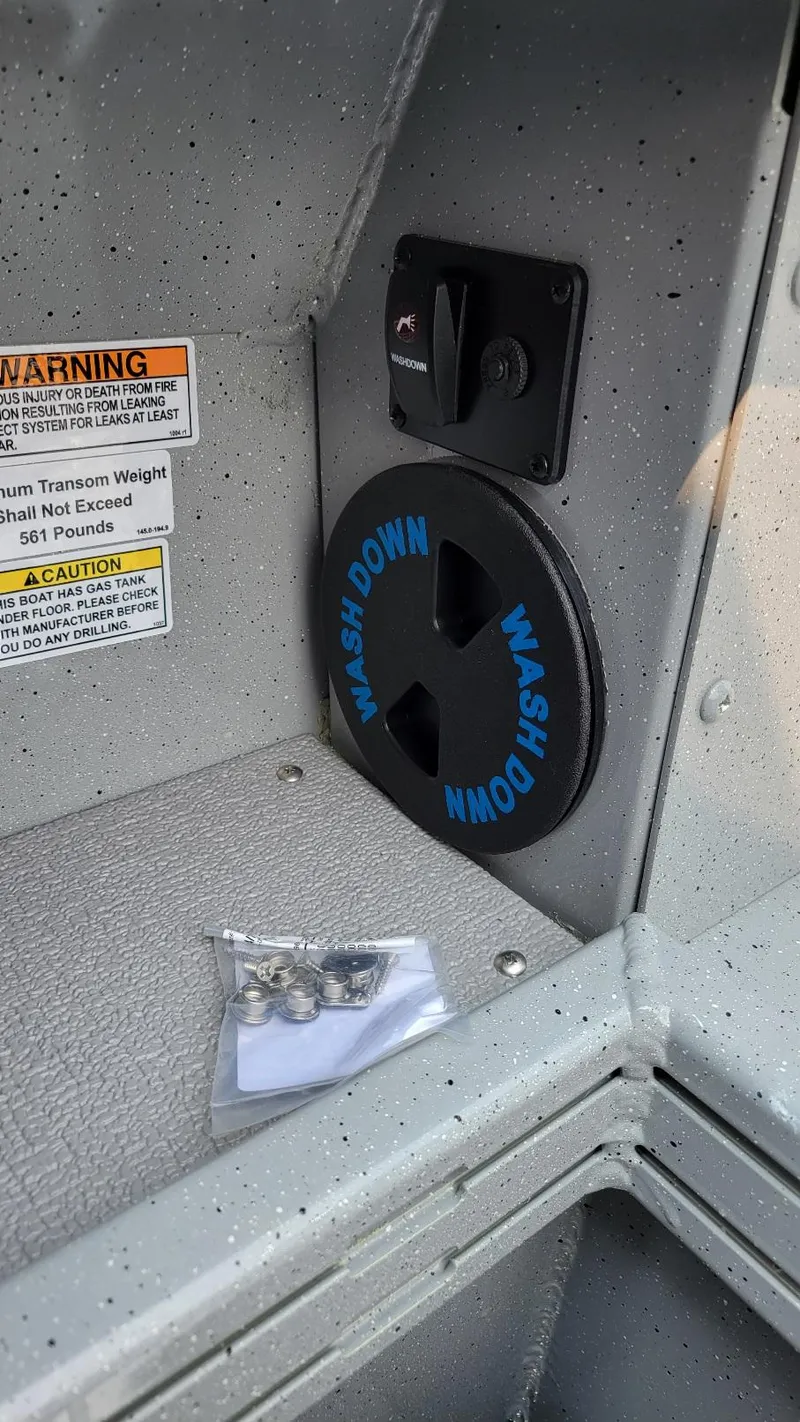 Slide: The Image of Interior view of Smoker Craft Phantom 18 X2 boat, featuring washdown system and warning labels. - 11