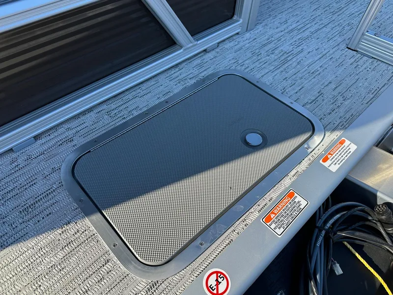 Slide: The Image of 2025 Bennington 188 SS Family Fish Pontoon deck with storage compartment and safety warnings. - 37