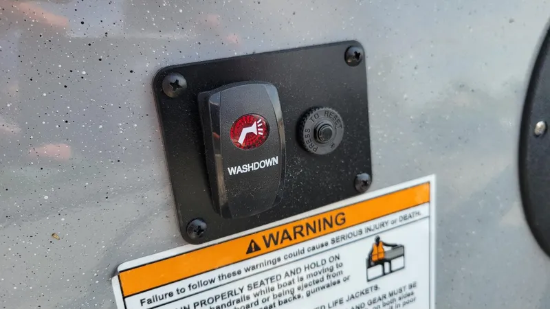 Slide: The Image of Washdown switch and warning label on 2026 Smoker Craft Pro Sportsman 2072 boat. - 13