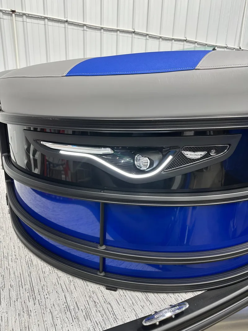 Slide: The Image of 2025 Bennington 22 MFB Tritoon with sleek blue and gray design, featuring modern lighting. - 17