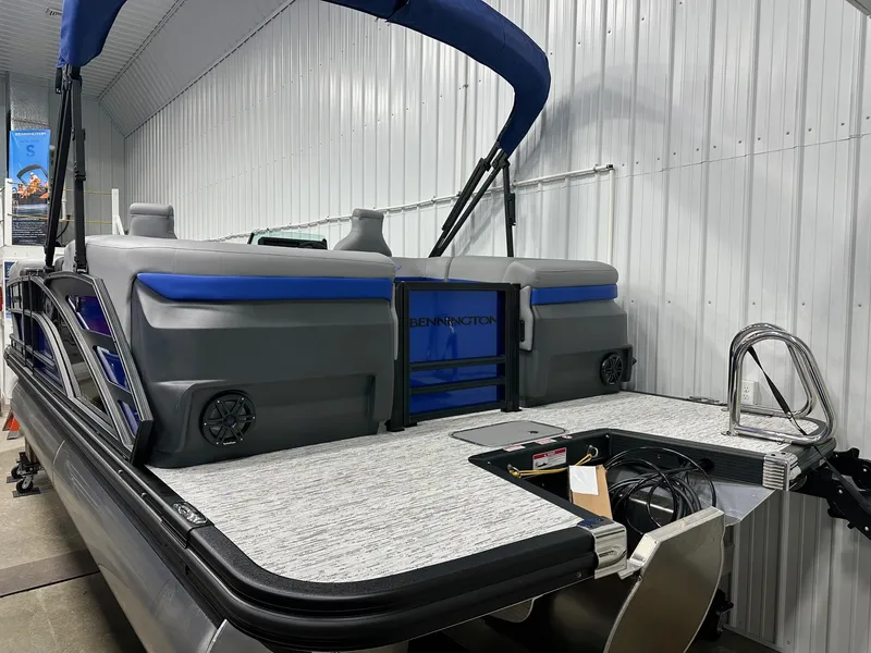 Slide: The Image of 2025 Bennington 22 MFB Tritoon with blue accents, showcased indoors. - 25