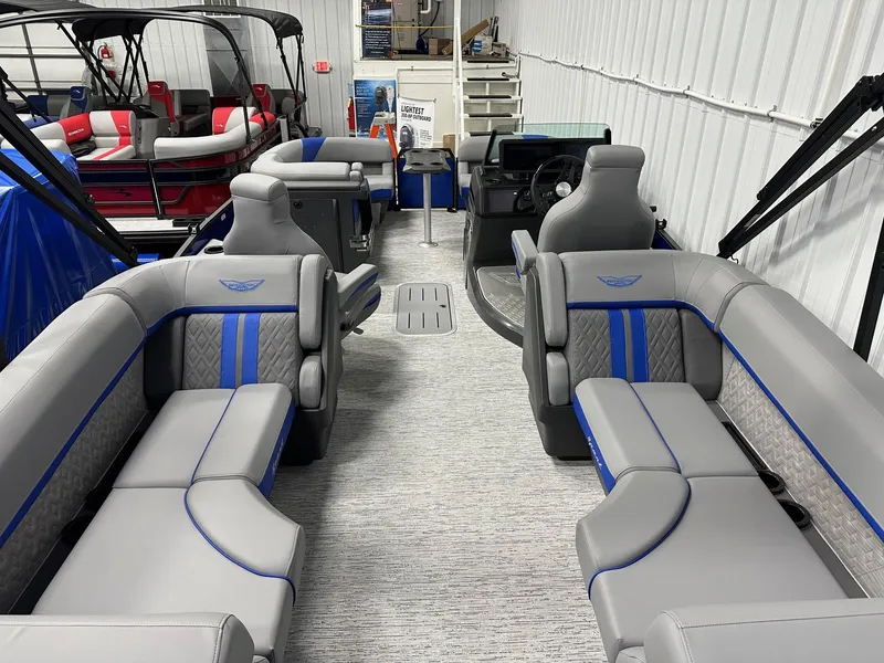 Slide: The Image of 2025 Bennington 22 MFB Tritoon with luxurious gray and blue seating in showroom. - 28