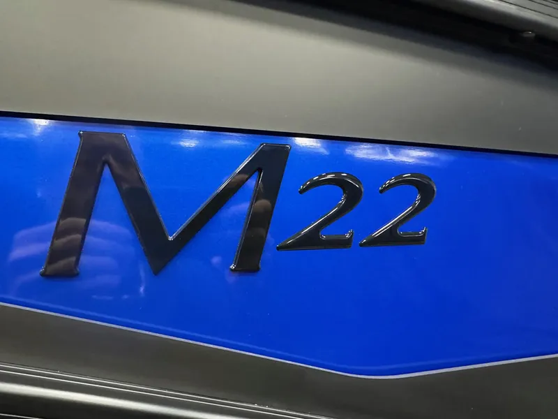 Slide: The Image of Close-up of Bennington 22 MFB Tritoon logo on blue background, 2025 model. - 4