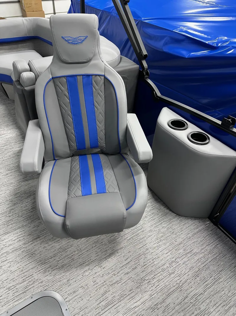 Slide: The Image of 2025 Bennington 22 MFB Tritoon interior with gray and blue seating and cup holders. - 8