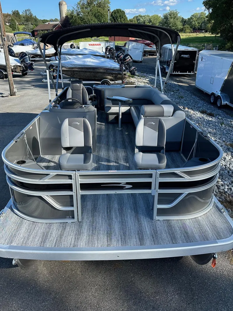 Slide: The Image of 2025 Bennington 21 SF pontoon boat with four fishing seats, docked outdoors. - 15