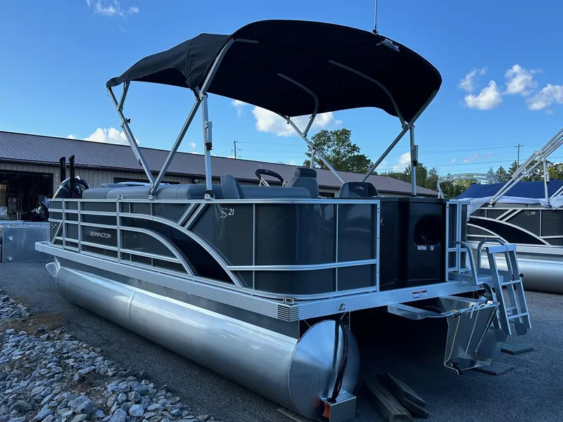Slide: The Image of 2025 Bennington 21 SF pontoon boat with canopy, in stock, parked outdoors. - 31