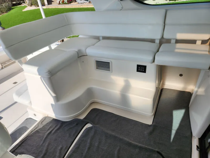 Slide: The Image of 2004 Tiara Yachts 38 Open interior seating area with white cushions and carpeted floor. - 15