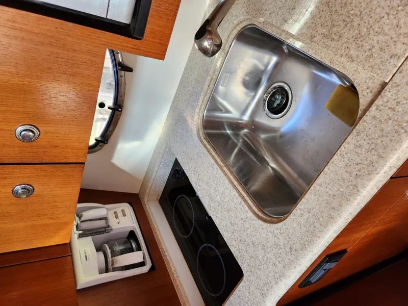 Slide: The Image of 2004 Tiara Yachts 38 Open kitchen with sink, stove, and wooden cabinetry. - 18