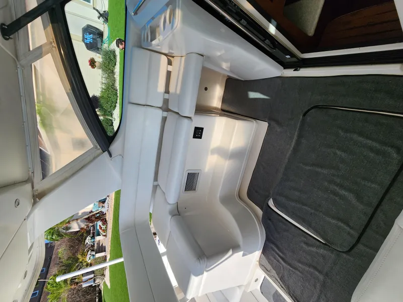 Slide: The Image of Interior of 2004 Tiara Yachts 38 Open, featuring white seating and carpeted flooring. - 25