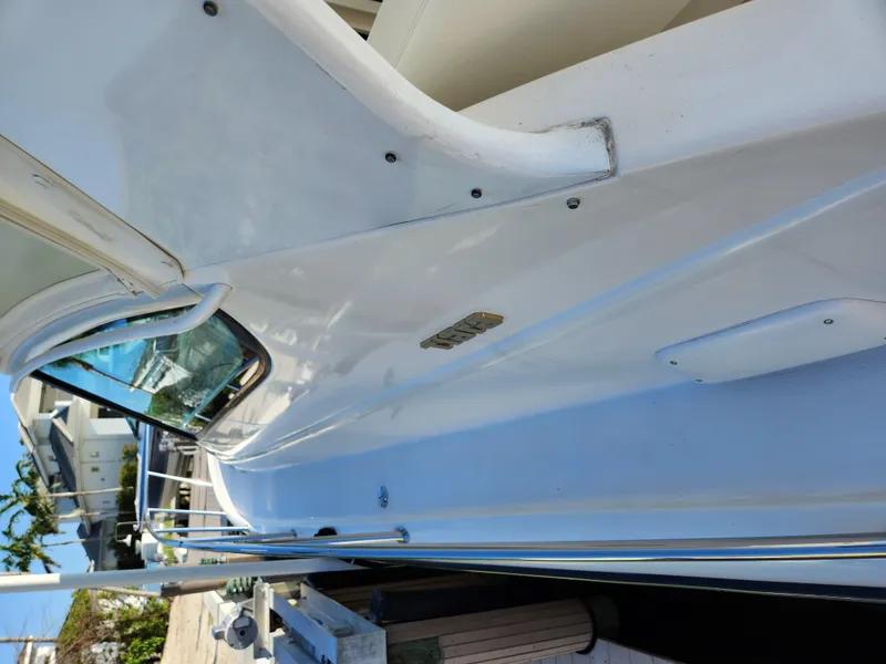 Slide: The Image of 2004 Tiara Yachts 38 Open, side view, docked, showcasing sleek design and white exterior. - 27