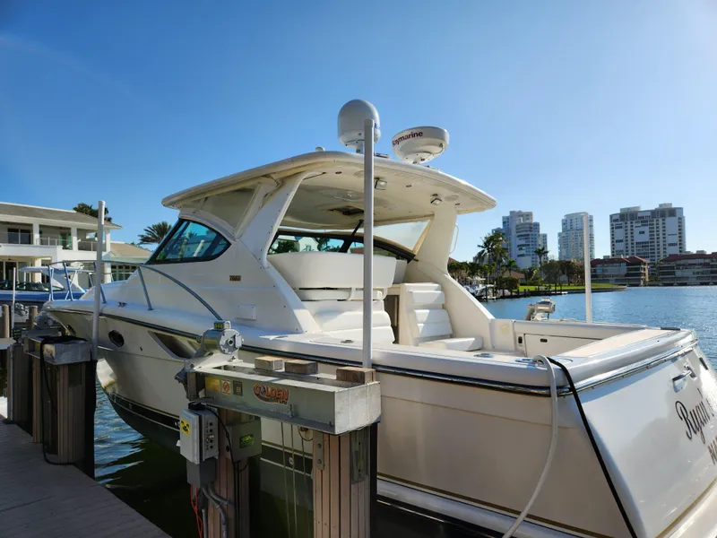 Slide: The Image of 2004 Tiara Yachts 38 Open docked by waterfront buildings under clear blue sky. - 28