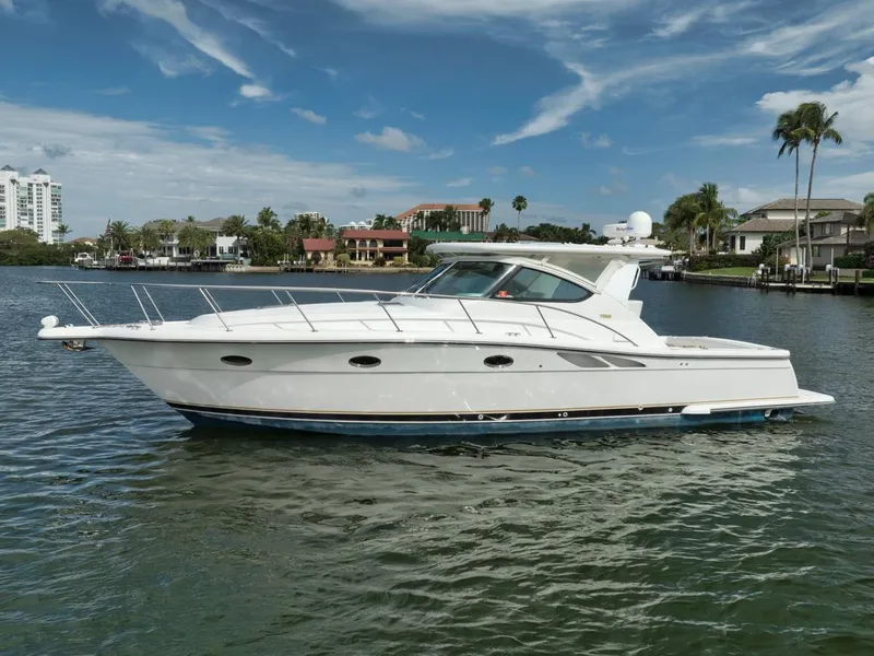 Slide: The Image of 2004 Tiara Yachts 38 Open cruising on a scenic waterway under a clear blue sky. - 35
