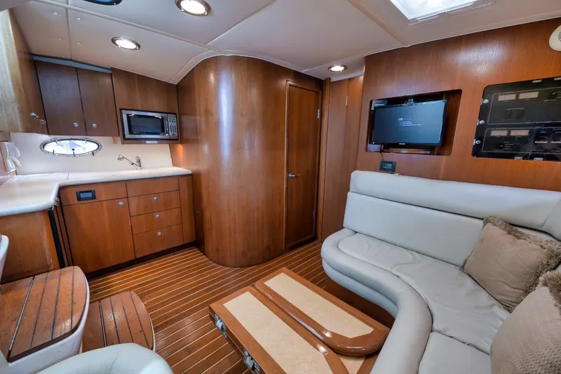 Slide: The Image of Interior of 2004 Tiara Yachts 38 Open, featuring wood cabinetry and plush seating. - 48
