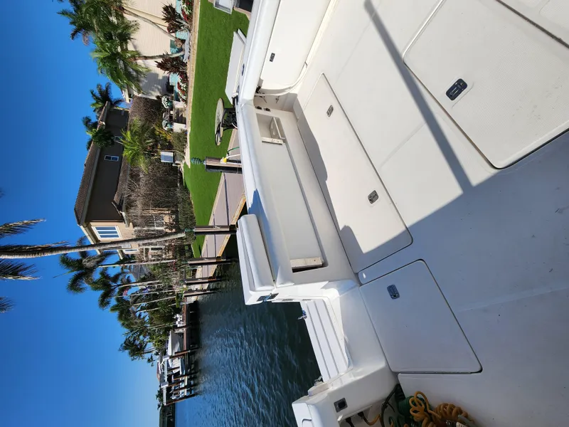 Slide: The Image of 2004 Tiara Yachts 38 Open docked near waterfront homes and palm trees. - 9