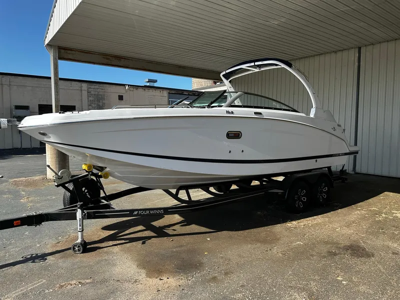 Slide: The Image of 2023 Four Winns HD8 OB boat on a trailer under a canopy. - 1