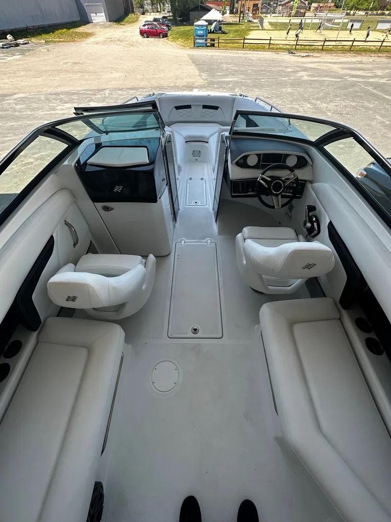 Slide: The Image of 2023 Four Winns HD8 OB boat interior with white seating and modern dashboard. - 16